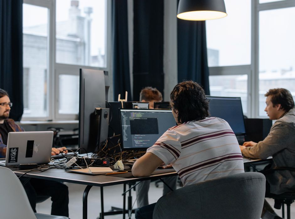 Software development team collaborating on code in a modern tech office